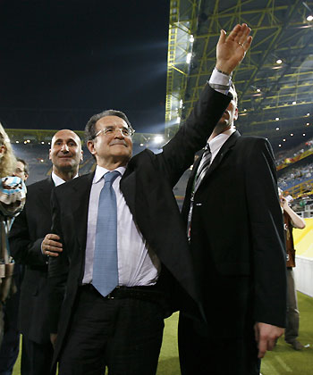 Italy's Prime Minister Romano Prodi (C) waves as he leaves the stadium with his security personnel at the end of their World Cup 2006 semi-final soccer match against Germany in Dortmund July 4, 2006.