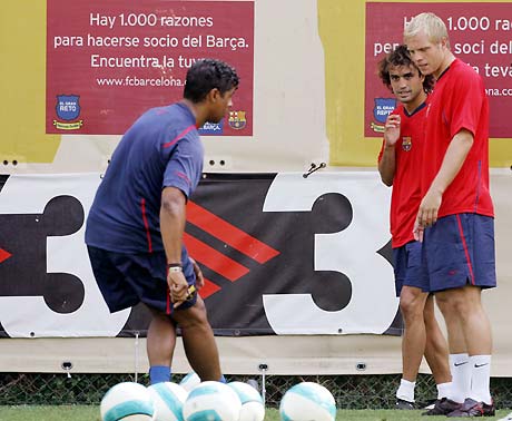 Barcelona's Eidur Gudjohnsen (R) and Santiago Ezquerro (C) listen to coach Frank Rijkaard during their first training session for the new season in Barcelona July 17, 2006. 