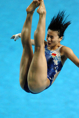 Guo Jingjing reacts during a flag-raising ceremony after winning gold at women's one-meter sprintboard match at 15th World Cup in Changshu, China, Wednesday. [Xinhua]