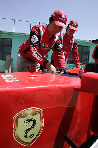 Brothers Zhao Xiushun (L) and Zhao Xiuguo prepare to drive their homemade model of Formula One car outside their house in Tangshan, Hebei Province, some 180km (113 miles) east of Beijing July 21, 2006. Zhao Xiuguo and his brother Zhao Xiushun built the car from scrap metal and said that they wanted to design and build the first Formula One racecar in China.
