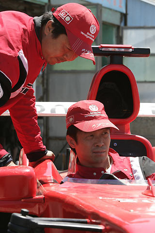 Brothers Zhao Xiushun (L) and Zhao Xiuguo prepare to drive their homemade model of Formula One car outside their house in Tangshan, Hebei Province, some 180km (113 miles) east of Beijing July 21, 2006. Zhao Xiuguo and his brother Zhao Xiushun built the car from scrap metal and said that they wanted to design and build the first Formula One racecar in China.