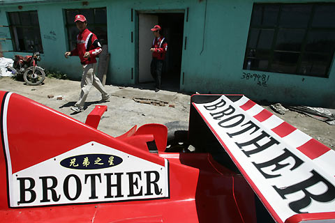 Brothers Zhao Xiushun (L) and Zhao Xiuguo prepare to drive their homemade model of Formula One car outside their house in Tangshan, Hebei Province, some 180km (113 miles) east of Beijing July 21, 2006. Zhao Xiuguo and his brother Zhao Xiushun built the car from scrap metal and said that they wanted to design and build the first Formula One racecar in China.