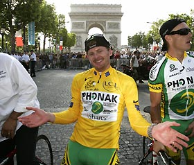 Phonak's team rider Floyd Landis of the U.S., wearing the leader's yellow jersey, celebrates as he takes his lap of honor around the Champs Elysees after winning the 93rd Tour de France cycling race after the final stage between Sceaux-Antony and the Champs-Elysees in Paris, July 23, 2006.