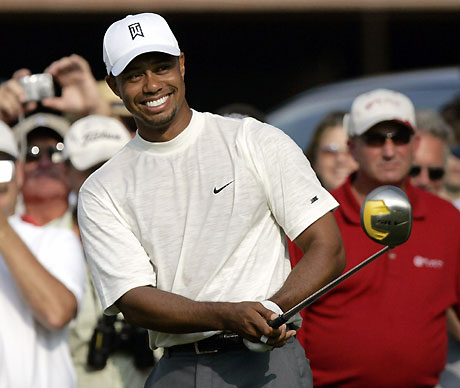 Tigers Woods smiles before his shot from the 10th tee during the Buick Open Pro-Am golf tournament in Grand Blanc, Michigan August 2, 2006. [Reuters]