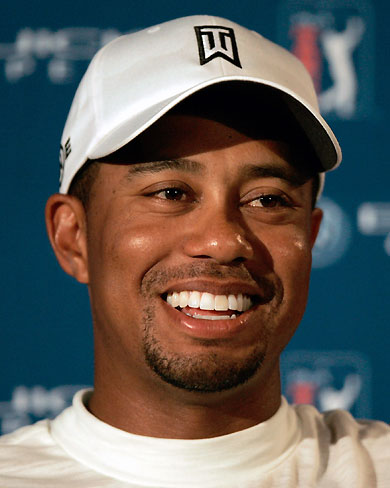 Former Super Bowl Champion Pittsburgh Steelers running back Jerome Bettis (L) laughs with Tigers Woods of the U.S. after Bettis shot the ball out of the rough during the Buick Open golf tournament in Grand Blanc, Michigan August 2, 2006. 