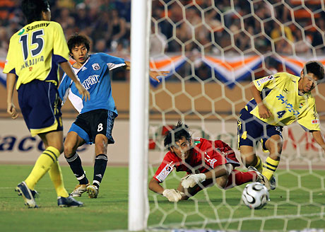 China's Dalian Shide midfielder Zhu Ting (2nd L) kicks the ball past goal keeper Masahiro Okamoto of Japan's JEF United Chiba during the East Asian Champions soccer cup in Tokyo August 5, 2006.