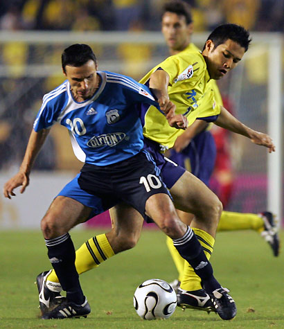 China's Dalian Shide midfielder Miodrag Pantelic (L) fights for the ball with Japan's JEF United Chiba defender Kozo Yuki during the East Asian Champions soccer cup in Tokyo August 5, 2006.