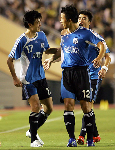 China's Dalian Shide forward Zou Jie (L) celebrates his goal with defender Wang Sheng (C) during East Asian Champions Cup against Japan's JEF United Chiba in Tokyo August 5, 2006. 