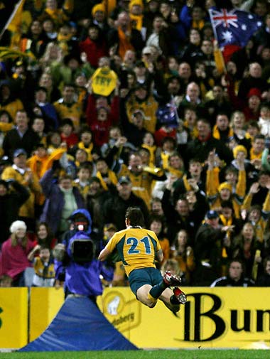 Australia's Mat Rogers dives over to score a try during the Tri-Nations rugby union Test match against South Africa in Sydney August 5, 2006. Australia defeated South Africa 20-18. 
