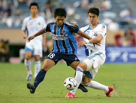 South Korea's Ulsan Hyundai forward Lee Chun-soo (R) keeps the ball as China's Dalian Shide midfielder Zhao Ming Jian tackles during the East Asian Champions Cup at the National Stadium in Tokyo August 8, 2006.