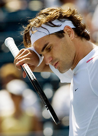 Roger Federer of Switzerland wipes his forehead during his second round match against Sebastien Grosjean of France at the Toronto Masters tennis tournament in Toronto August 9, 2006. Federer defeated Grosjean to advance.