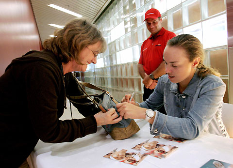 Tennis player Martina Hingis of Switzerland signs a purse during an autograph session in Montreal August 14, 2006. 