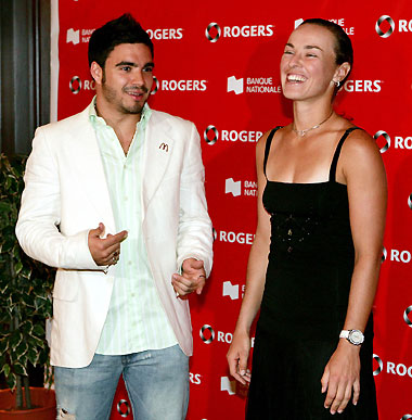 Tennis player Martina Hingis of Switzerland (R) shares a laugh with Olympic diver Alexandre Despatie of Canada while arriving for a fashion show during the second day at the Sony Ericsson WTA Tour in Montreal, Canada, August 13, 2006.