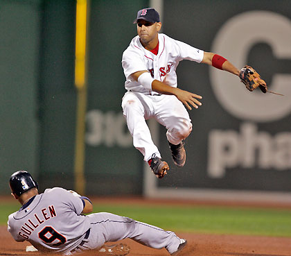Boston Red Sox shortstop Alex Cora avoids a sliding Detroit Tigers Carlos Guillen while turning a double play during the eigth inning of their American League MLB baseball game at Fenway Park in Boston, Massachusetts August 16, 2006. 