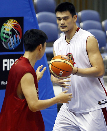 China's Yao Ming (R) passes to team mate Wang Zhizhi during practice for the world basketball championships in Sapporo August 18, 2006.