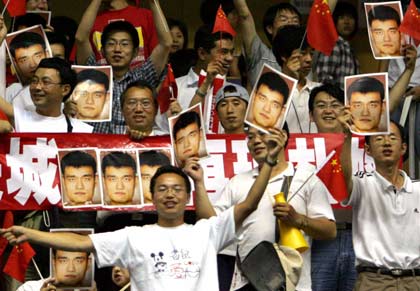 Chinese fans cheer as they hold portraits of Yao Ming before the first round game between China and the US at the world basketball championships in Sapporo, northern Japan August 20, 2006. [Reuters]