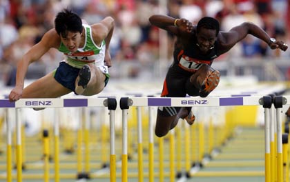 Xiang Liu of China (L) crosses a hurdle to win the 110 metres hurdles event at the IAAF World Athletics Final in Stuttgart on September 9, 2006. Liu won the race ahead of Dayron Robles of Cuba (R). 