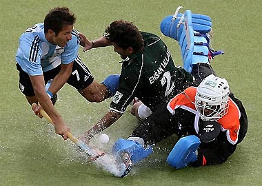 Argentina's Mario Nicolas Almada (L) fights for the ball with Pakistan's Ihsan Ullah (C) and goalkeeper Salman Akbar (R) during their Men's Field Hockey World Cup match at the Warsteiner Hockey Park stadium in Moenchengladbach September 11, 2006. 