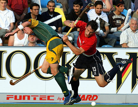 South Africa's Wayne Madsen (L) fights for the ball with England's Rob Moore during their Men's Field Hockey World Cup match at the Warsteiner Hockey Park stadium in Moenchengladbach September 13, 2006.