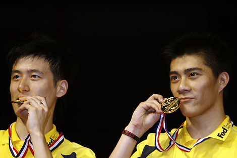 China's Cai Yun (L) and Fu Haifeng hold up their gold medals after their men's doubles final match at the World Badminton Championships in Madrid September 24, 2006. 