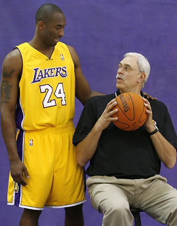 Los Angeles Lakers NBA basketball guard Kobe Bryant (L) chats to coach Phil Jackson as they wait to be photographed during media day in Los Angeles October 2, 2006. 