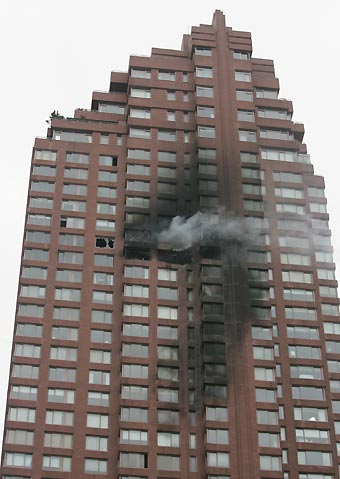 Smoke billows out the windows of a high-rise building after a small aircraft crashed into it in New York City October 11, 2006.