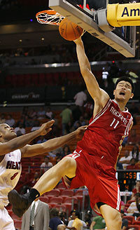 Miami Heat Antoine Walker (L) pulls Houston Rockets Yao Ming shirt as he goes up for a shot during fourth quarter NBA basketball action in Miami, Florida November 12, 2006. 
