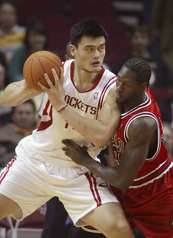 Chicago Bulls center Ben Wallace (R) closely guards Houston Rockets center Yao Ming during the first half of their NBA game in Houston November 16, 2006. 