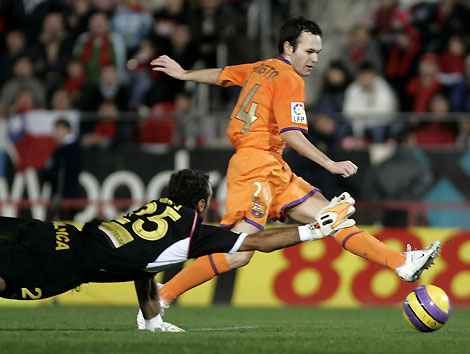 Barcelona's Andres Iniesta (R) scores against Real Mallorca as goalkeeper Antoni Prats tries to stop the ball during their Spanish first division soccer match at Ono Stadium in Palma de Mallorca November 19, 2006. Barcelona won the match 4-1. 