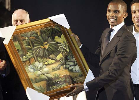 An Algerian Football Association official presents a painting to Samuel Eto'o of Cameroon (R) during a celebration to award the best African soccer players, in Algiers November 20, 2006. 