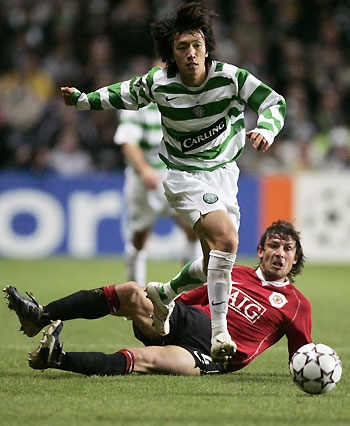 Celtic's Shunsuke Nakamura runs with the ball despite the challenge from Manchester United's Gabriel Henze during their Champions League Group F soccer match at Celtic Park in Glasgow, Scotland November 21, 2006.