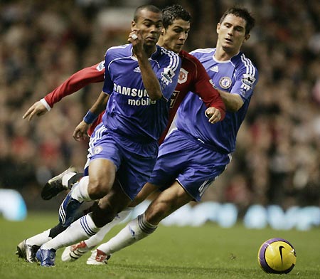 Chelsea's Ashley Cole (L) and Frank Lampard (R) challenge Manchester United's Christiano Ronaldo for the ball during their English Premier League soccer match in Manchester, northern England, November 26, 2006. 