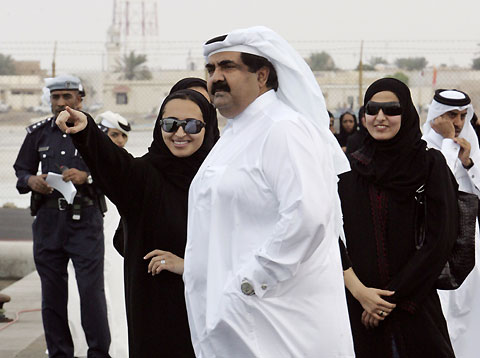 Qatar's Emir Sheikh Hamad bin Khalifa al-Thani (C) and his family look at the torch for the 15th Asian Games flame in the northern Qatari city of Ruwais, 100 km from Doha, November 25, 2006. The 2006 Asian Games will take place in the Qatari capital Doha December 1 to 15. 
