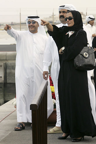 Qatar's Emir Sheikh Hamad bin Khalifa al-Thani (R) and his family look at the torch for the 15th Asian Games flame in the northern Qatari city of Ruwais, 100 km from Doha, November 25, 2006. The 2006 Asian Games will take place in the Qatari capital Doha December 1 to 15. 