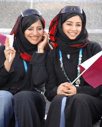 Volunteers waves outside athletes village of 2006 Asian Games in Doha, November 27, 2006.