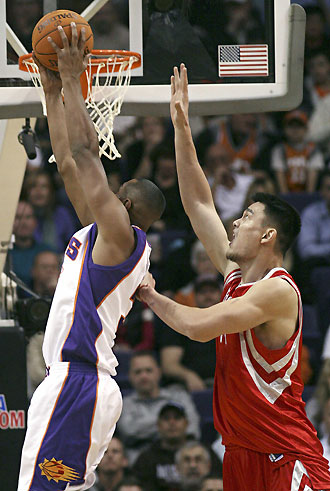 Houston Rockets' Yao Ming (R) of China tries to block this reverse dunk by Phoenix Suns' Boris Diaw (L) of France during first quarter NBA action in Phoenix, Arizona, November 29, 2006. 