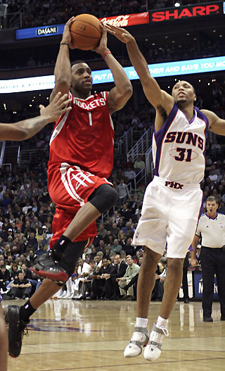 Houston Rockets Tracy McGrady (1) drives to the basket for a score while being guarded by Phoenix Suns Shawn Marion during first quarter NBA action in Phoenix, Arizona, November 29, 2006.