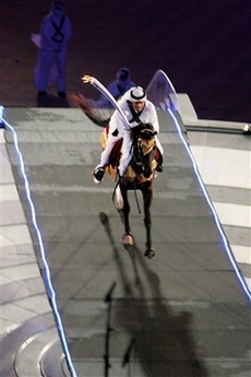A horseman rides his charge to the top of the stands to light the Asian Games flame during the Opening Ceremony of the 15th Asian Games in Doha, Qatar, Friday Dec. 1, 2006. (AP