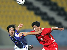 Japan's Honda Keisuke (L) fights for the ball with North Korea's Kim Song-chol during their 15th Asian Games Group F second round soccer match in Doha December 6, 2006. 