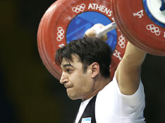 Alexander Urinov powers a lift during the 105kg category in the men's weight lifting at 2004 Athens Olympics in this August 24, 2004 file photo.