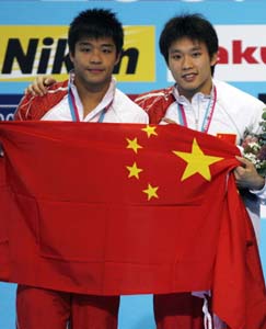 Luo Yutong (L) and He Chong of China pose for photographs after taking gold and silver, respectively, for the 1-metre springboard diving competition at the World Aquatics Championships in Melbourne March 21, 2007.