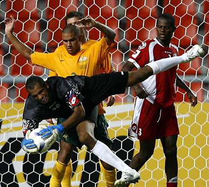 Australia's Patrick Kisnorbo reacts as Oman's goalkeeper Sulaiman Al Mazroui (bottom) flies through the air as his team mate Juma Al Wahaibi (R) looks on during their 2007 AFC Asian Cup Group A soccer match at Rajamangala Stadium in Bangkok July 8, 2007. 
