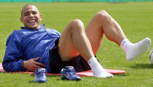 Ronaldo smiles as he takes off his shoes 