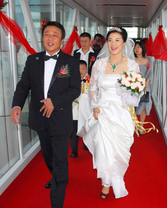 China's four-time Olympic table tennis gold medalist Wang Nan (R) ties the knot with her long-time partner Guo Bin aboard a yacht in Yantai, Shandong Province, September 27, 2008. Wang's teammate Ma Lin, the reigning Olympic men's table tennis champion, and Japan's most popular table tennis star Ai Fukuhara were best man and maid of honor respectively. [Xinhua]