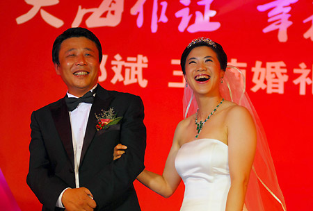 China's four-time Olympic table tennis gold medalist Wang Nan (R) laughs with her husband Guo Bin aboard a yacht to celebrate their wedding in Yantai, Shandong Province, September 27, 2008. [Xinhua]
