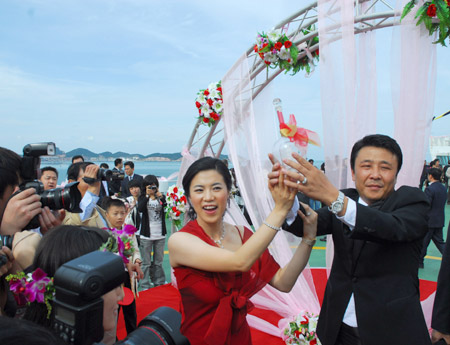 China's four-time Olympic table tennis gold medalist Wang Nan (L) ties the knot with her long-time partner Guo Bin aboard a yacht in Yantai, Shandong Province, September 27, 2008. Wang's teammate Ma Lin, the reigning Olympic men's table tennis champion, and Japan's most popular table tennis star Ai Fukuhara were best man and maid of honor respectively. [Xinhua]