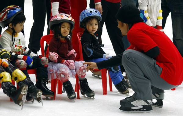 Former Olympic short track speed skating champion Apolo Anton Ohno of the US skates with a young Chinese skater during a promotion for the Special Olympics in Beijing. Apolo in Beijing for Special Olympics promotion