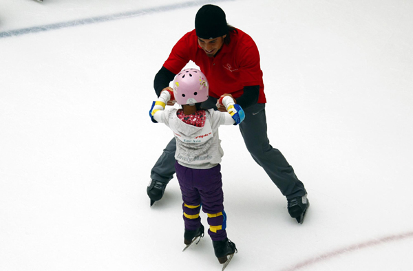 Former Olympic short track speed skating champion Apolo Anton Ohno of the US skates with a young Chinese skater during a promotion for the Special Olympics in Beijing. Apolo in Beijing for Special Olympics promotion