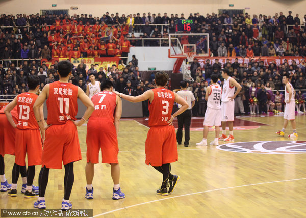 Qingdao palyers stand on the court waiting for the end of their CBA League game against Bayi Fubang in Ningbo, Zhejiang province, Jan 9, 2012, in protest of the referees' controversial decisions. Controversial refereeing decisions upstage in CBA match