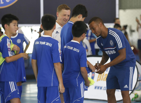 Chelsea's defender Ryan Bertrand signs an autograph during a coaching session as part of the team's 'Here To Play, Here To Stay, Asia Tour 2013' in Petaling Jaya outside Kuala Lumpur, July 20, 2013. Chelsea secures easy win in Malaysia